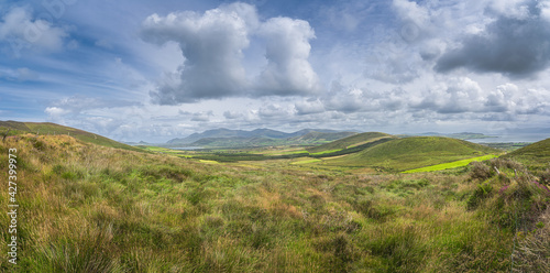 Large panorama with valley, green fields, forest and lake, surrounded by hills and mountains, Dingle Peninsula, Wild Atlantic Way, Kerry, Ireland