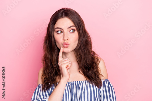 Photo of nice optimistic brunette lady look empty space blow kiss wear blue t-shirt isolated on pastel pink color background