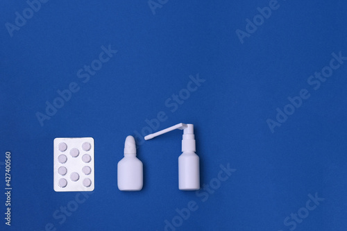 medicines for colds and flu. nasal spray, throat spray, tablets in the package. on a blue background. copy space