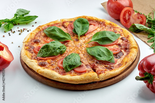 Classic Italian pizza margarita with tomatoes, basil and red sauce on a plate. White background. Italian Cuisine. Selective focus