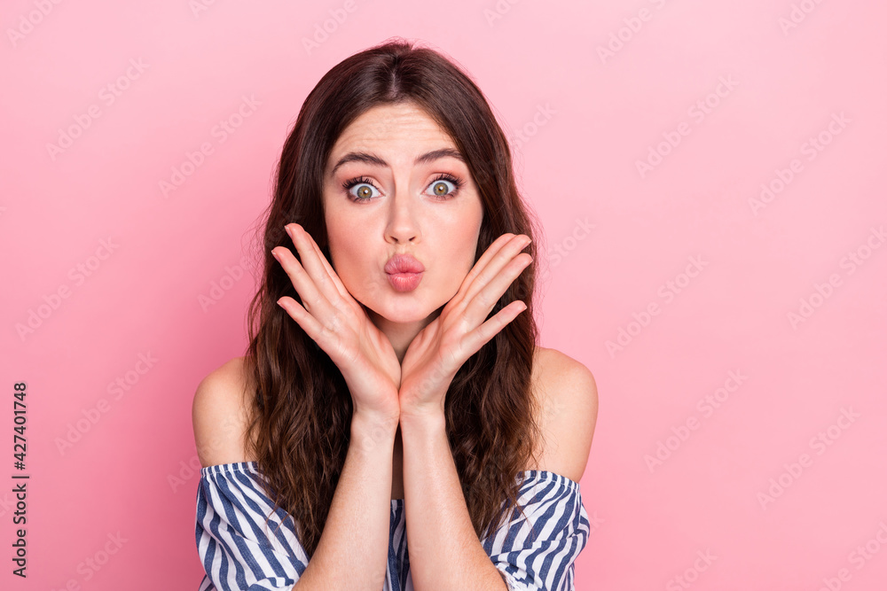 Photo of nice impressed brunette lady hands face blow kiss wear blue dress isolated on pink color background Photo of nice impressed brunette lady hands face blow kiss wear blue dress isolated on pink color background
