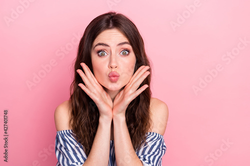 Photo of nice impressed brunette lady hands face blow kiss wear blue dress isolated on pink color background