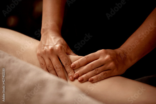 No face close-up of the masseur hands on the client leg. Wellness massage of slender legs in the massage room. Anti-cellulite massage. Beauty salon. The concept of alternative medicine.