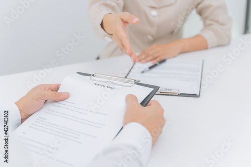 Examiner reading a resume during job interview at office