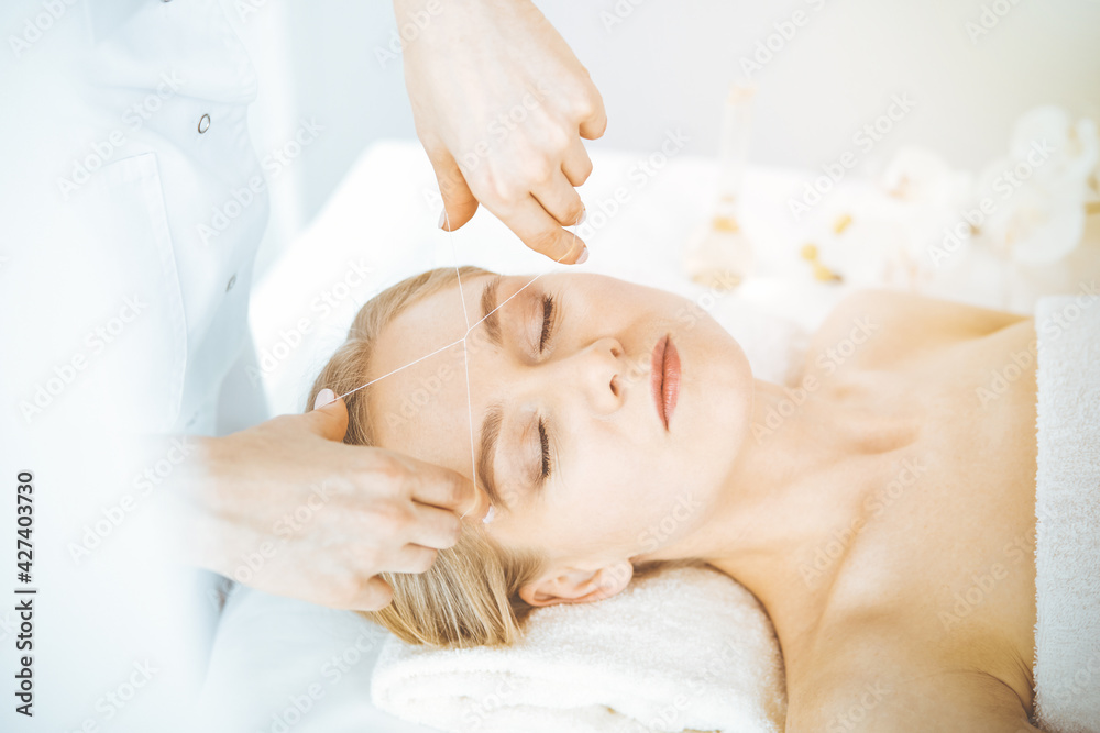 Blonde woman getting face depilation procedure. Beauty and Spa salon concept