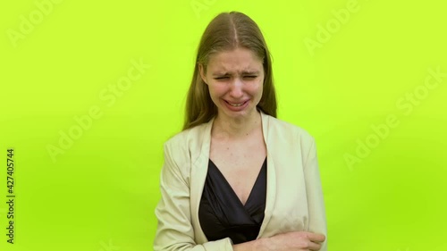 Woman having stomach ache and cramps crying in space studio