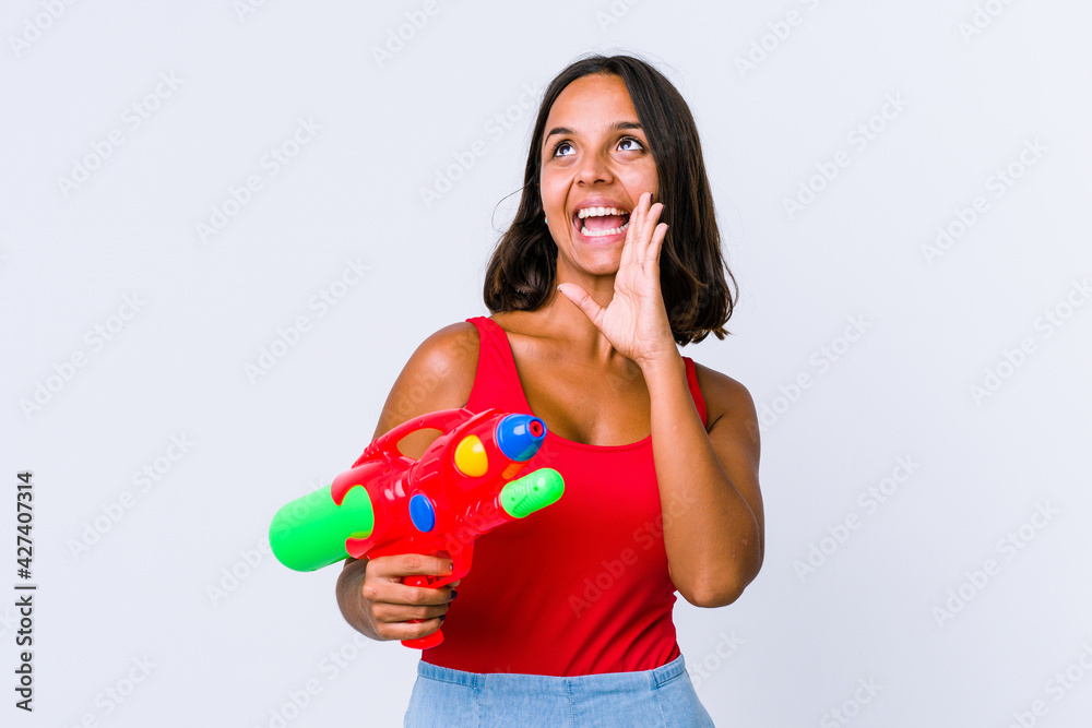 Young mixed race woman holding a water gun isolated shouting excited to front. Young mixed race woman holding a water gun isolated shouting excited to front.