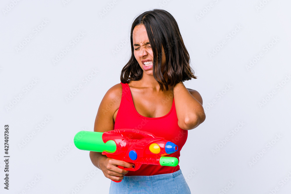 Young mixed race woman holding a water gun isolated suffering neck pain due to sedentary lifestyle. Young mixed race woman holding a water gun isolated suffering neck pain due to sedentary lifestyle.
