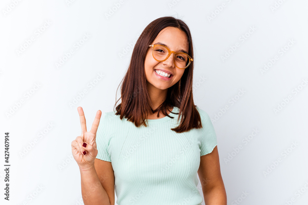 Young mixed race woman isolated joyful and carefree showing a peace symbol with fingers. Young mixed race woman isolated joyful and carefree showing a peace symbol with fingers.