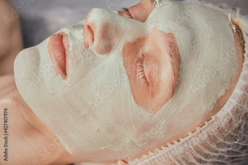 Cleansing the skin with natural cosmetics. There is green clay on the man s face. Facial skin care.