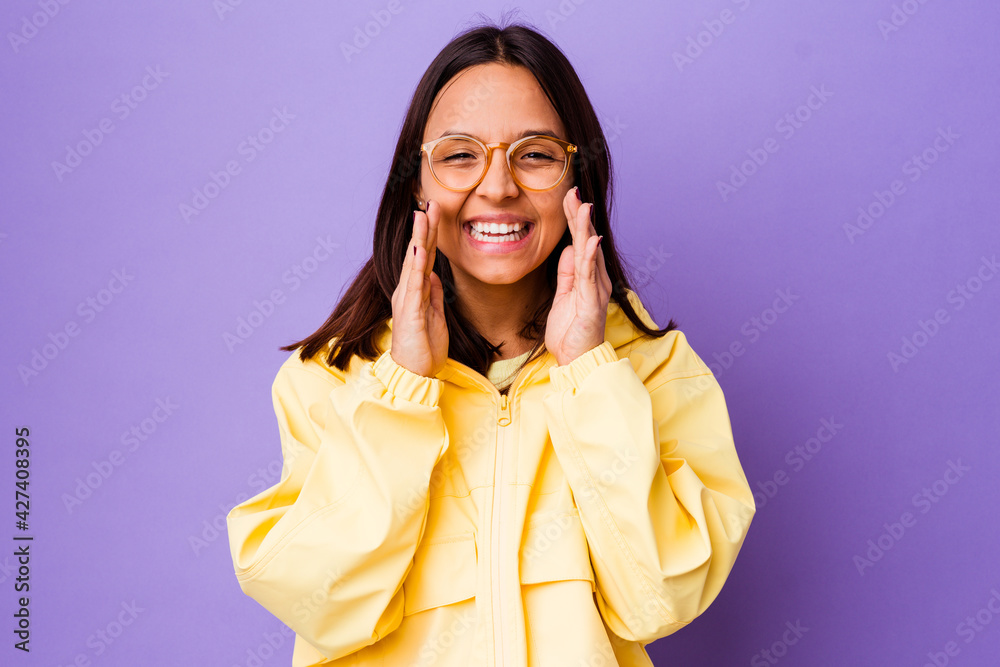 Young mixed race woman isolated saying a gossip, pointing to side reporting something. Young mixed race woman isolated saying a gossip, pointing to side reporting something.