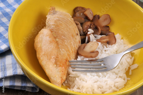 Escalope de poulet avec du riz et des champignons servis dans une assiette en gros plan photo