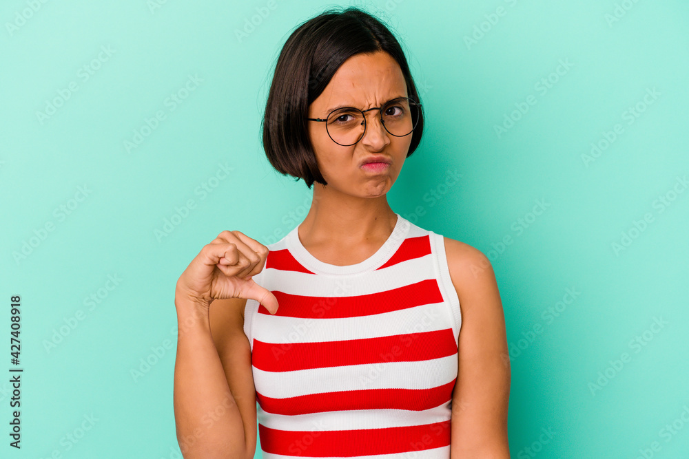Young mixed race woman isolated on blue background showing thumb down, disappointment concept. Young mixed race woman isolated on blue background showing thumb down, disappointment concept.