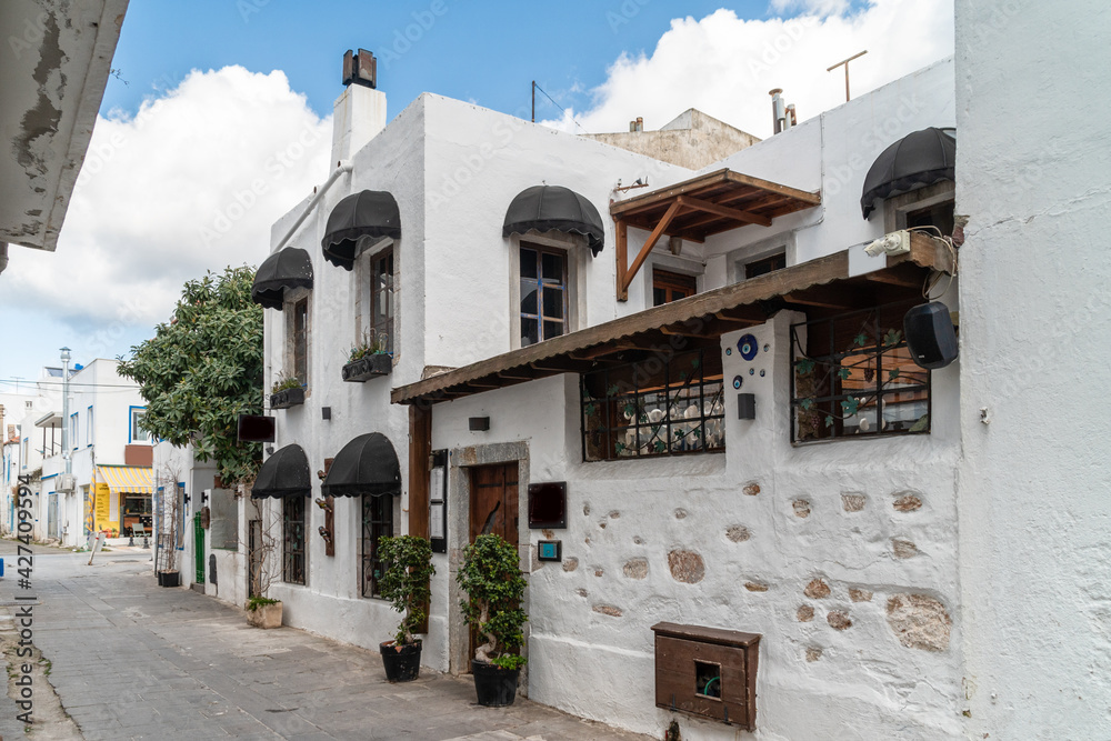 Fototapeta premium Beautiful Streets of old Marmaris. Narrow streets with stairs among the houses with white brick, green plants and flowers in the old town of resort of in Turkey