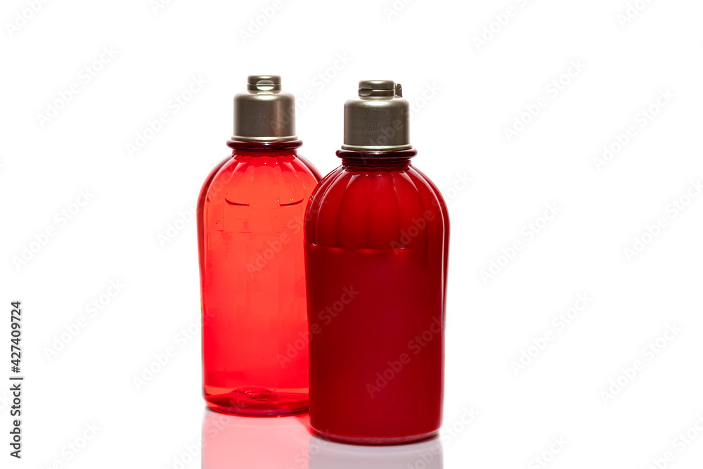 Red bottles for shower gel and cream on a white background. Lightweight plastic jars. On white background. Hard shadows. Isolates.
