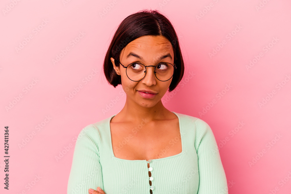 Young mixed race woman isolated on pink background unhappy looking in camera with sarcastic expression.