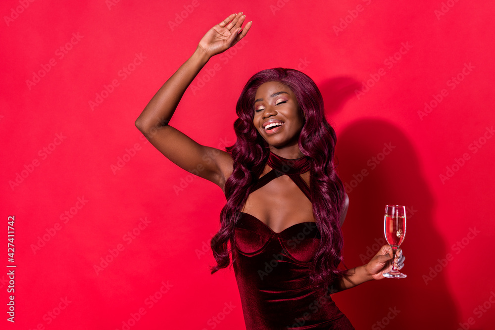 Photo of young cheerful black girl happy positive smile drink champagne party have fun isolated over red color background Photo of young cheerful black girl happy positive smile drink champagne party have fun isolated over red color background