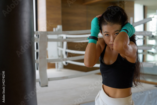 Asian woman kick boxer ready for exercise at gym © Ranta Images