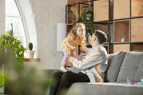 Happy father and little cute daughter at home. Family time, togehterness, parenting and happy childhood concept. Weekend with sincere emotions. photo