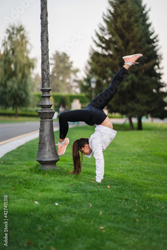 Attractive skinny woman doing a backbend while showing a somersault.