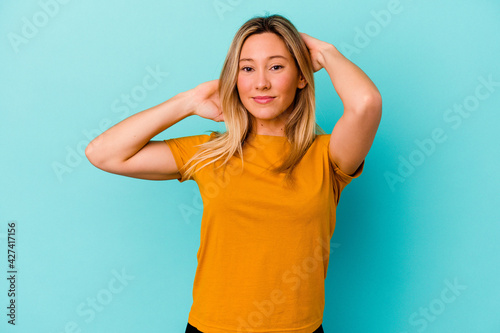 Young mixed race woman isolated on blue background stretching arms, relaxed position.