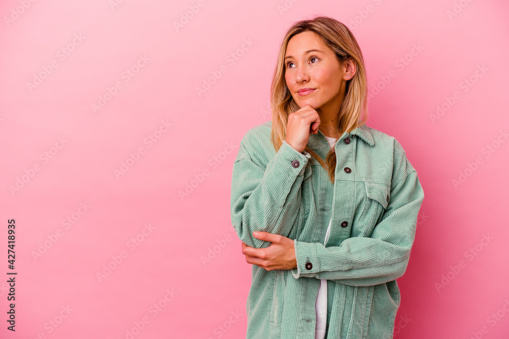 Young mixed race woman isolated on pink background looking sideways with doubtful and skeptical expression. Young mixed race woman isolated on pink background looking sideways with doubtful and skeptical expression.