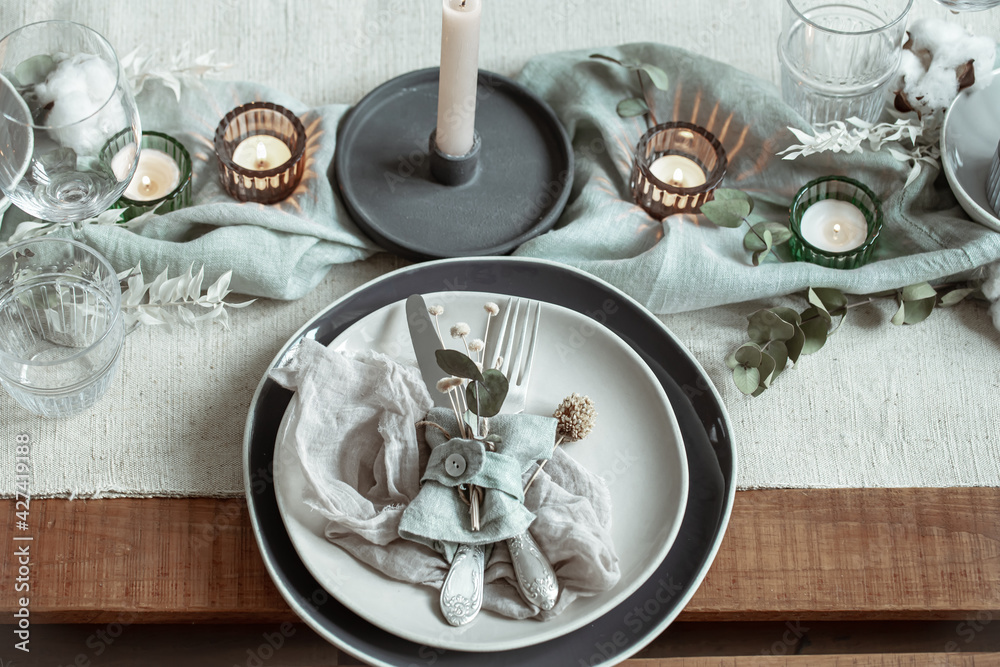 Festive table setting in vintage style with dry sprigs of leaves close up.