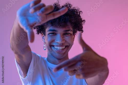 Dark-skinned guy making pictures with imaginary camera