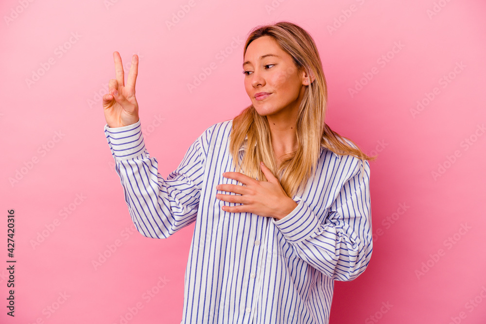 Young mixed race woman isolated on pink background taking an oath, putting hand on chest. Young mixed race woman isolated on pink background taking an oath, putting hand on chest.