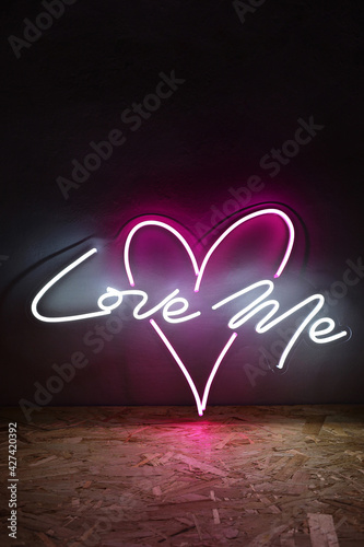 White and pink neon heart with the inscription love me. Trendy style. Wedding design. Neon sign. Custom neon. Home decor.  photo