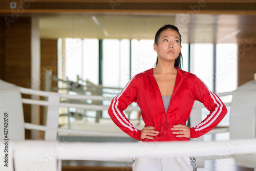 Free Download Portrait of Asian woman kick boxer thinking at gym boxing ring - GFXLoad