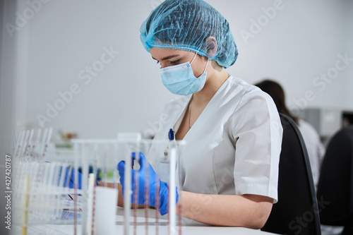 Concentrated serious biochemist in a disposable bouffant cap at work