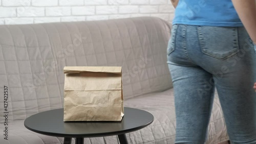 Woman with take away bag. The woman put the package on the take-out table.