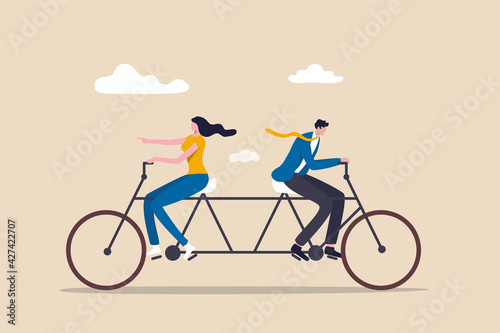 Business conflict, controversy or disagreement causing problem and failure concept, businessman and businesswoman colleagues or working team trying hard riding bicycle in opposite direction.