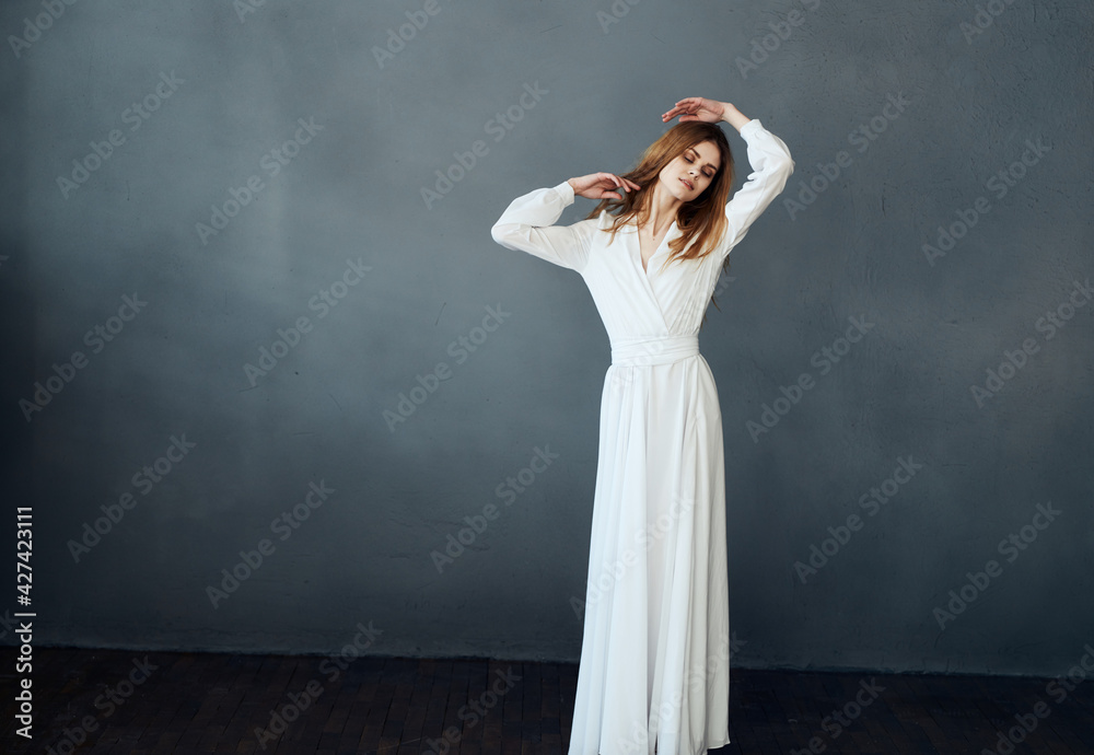 Woman in white dress on gray background red hair model romance Woman in white dress on gray background red hair model romance