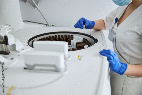 Εκτύπωση καμβά Biochemist holding a glass vial with liquid over the reagent tray