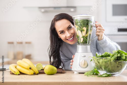 Vitamins packed blender ready to be mixed into a smoothie by a beautiful woman photo