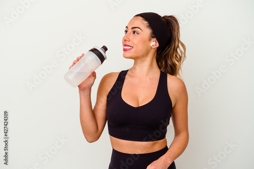 Young sporty fitness woman drinking water from bottle isolated on white background