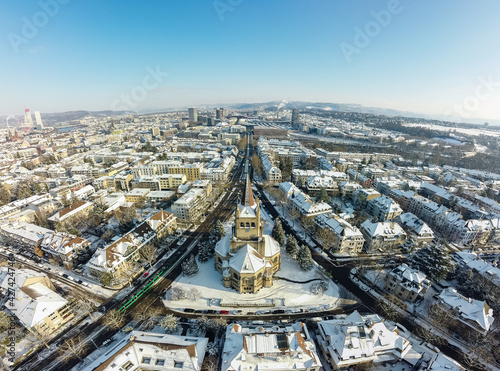 Aerial drone shot of St. Paul's Church (Pauluskirche) at winter, covered with snow at sunset in Basel, Switzerland