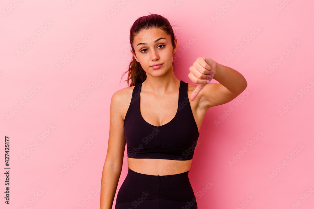 Young sport Indian woman isolated on pink background showing a dislike gesture, thumbs down. Disagreement concept. Young sport Indian woman isolated on pink background showing a dislike gesture, thumbs down. Disagreement concept.