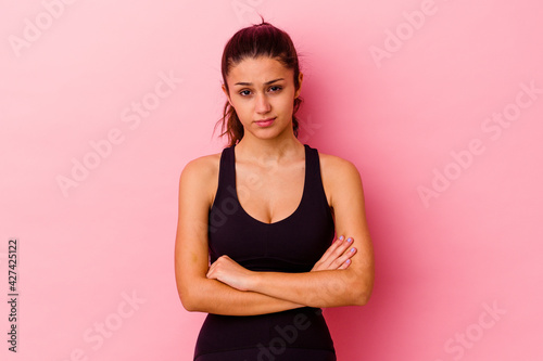 Young sport Indian woman isolated on pink background unhappy looking in camera with sarcastic expression. © Asier