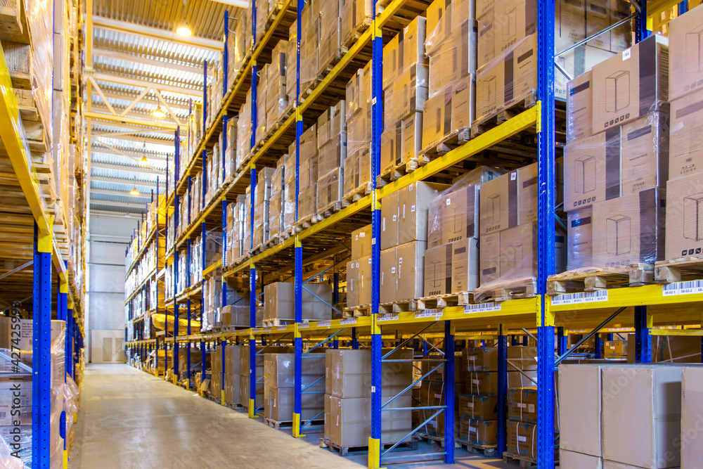 Interior of a modern warehouse storage with rows and goods boxes on high shelves Interior of a modern warehouse storage with rows and goods boxes on high shelves