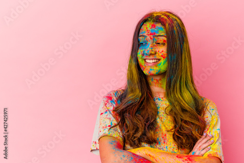 Young Indian woman celebrating holy festival isolated on white background smiling confident with crossed arms.
