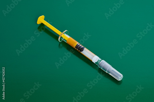 Studio shot of syringe over green background