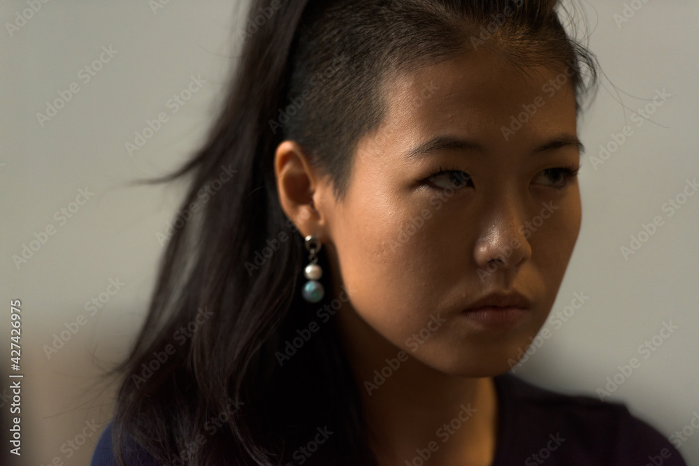 Close-up portrait of beautiful rebel Asian woman face outdoors Close-up portrait of beautiful rebel Asian woman face outdoors