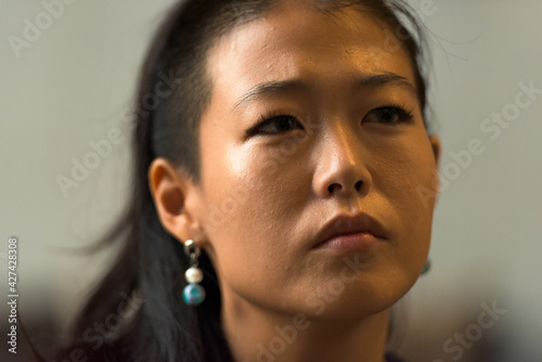 Close-up portrait of beautiful rebel Asian woman face thinking outdoors