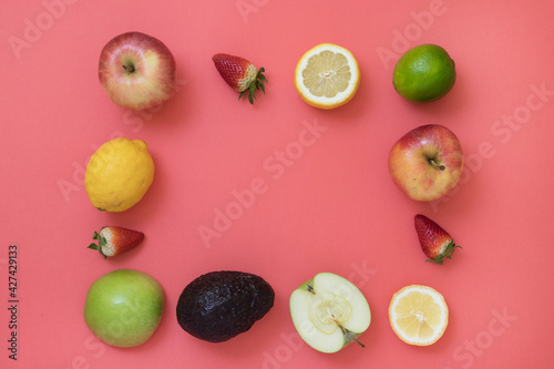 Frame with fresh seasonal fruits on pink background
