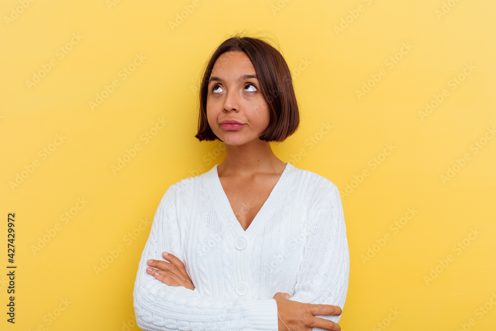 Young mixed race woman isolated on yellow background tired of a repetitive task. Young mixed race woman isolated on yellow background tired of a repetitive task.