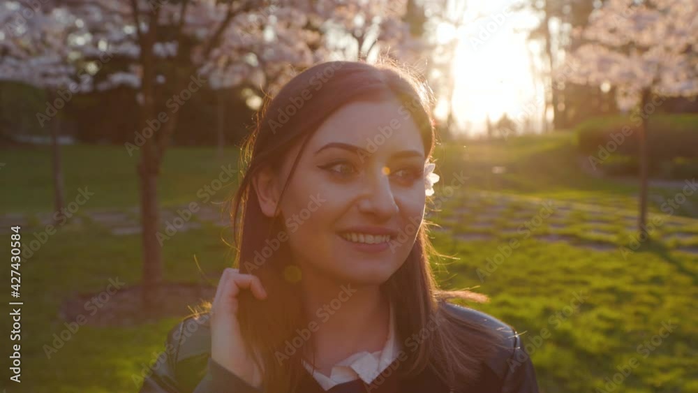 Happiness concept of a young woman with cherry blossoms smiling, sunburst. 4k 24FPS. Happiness concept of a young woman with cherry blossoms smiling, sunburst. 4k 24FPS.