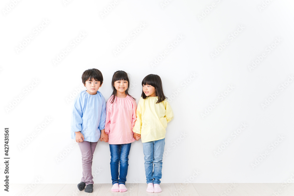 壁に並ぶ3人の幼稚園児 壁に並ぶ3人の幼稚園児